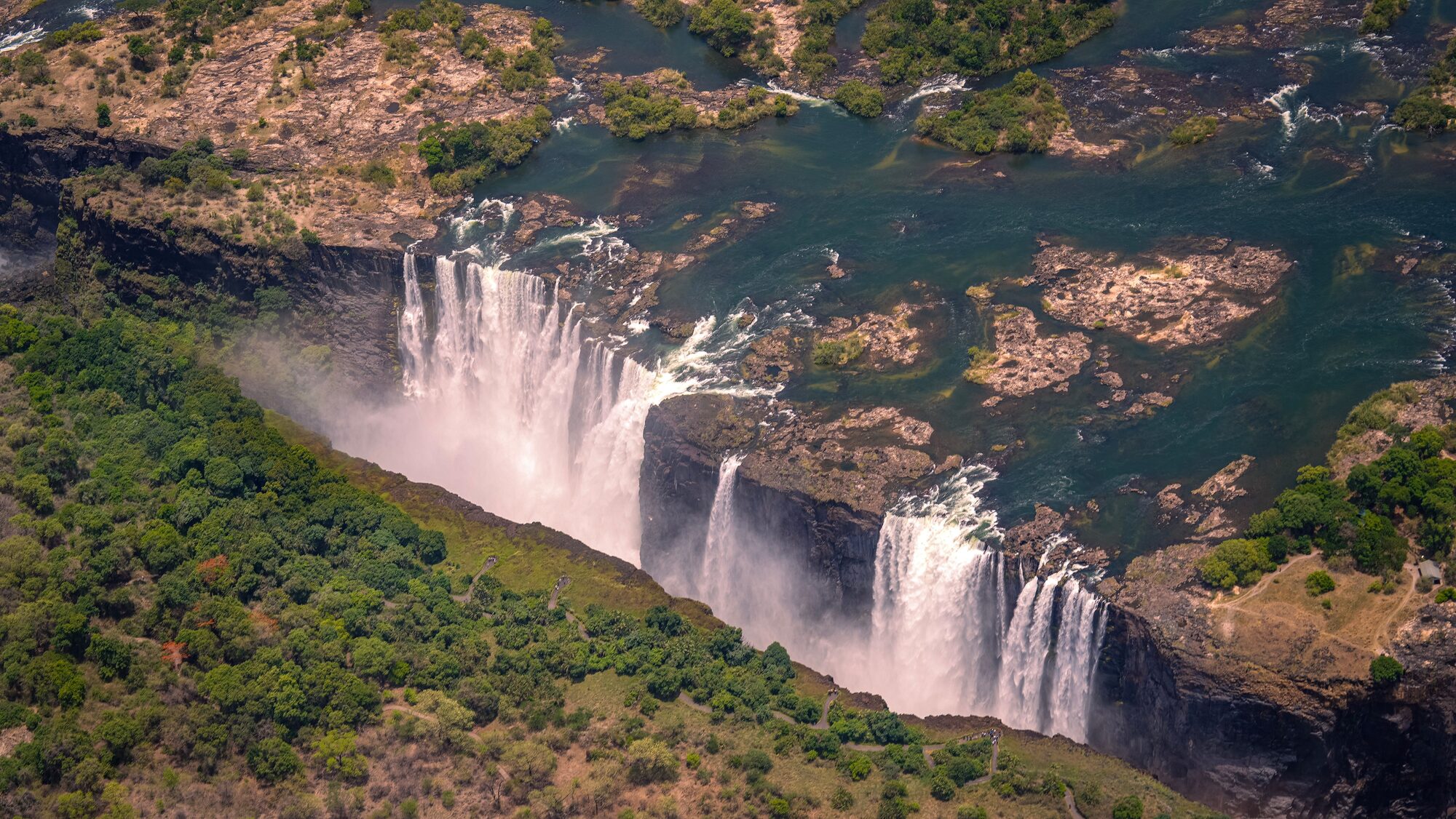 Aerial view of Victoria Falls on the Zambezi River, showing the falls plunging into the gorge between Zimbabwe and Zambia